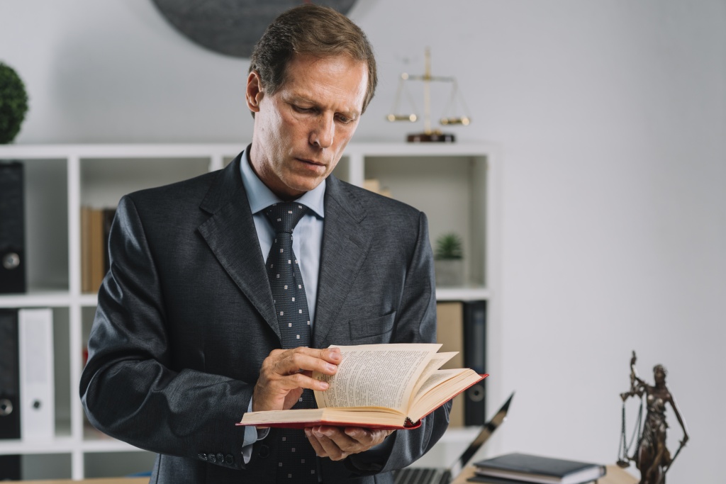 mature-lawyer-turning-pages-law-book-courtroom.jpg судья
